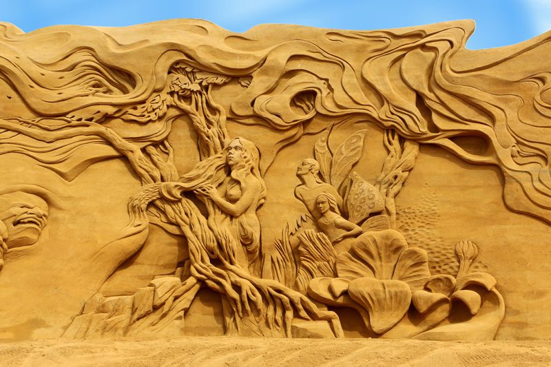 Sandskulptur af kvinde i et eventyr med natur og feer