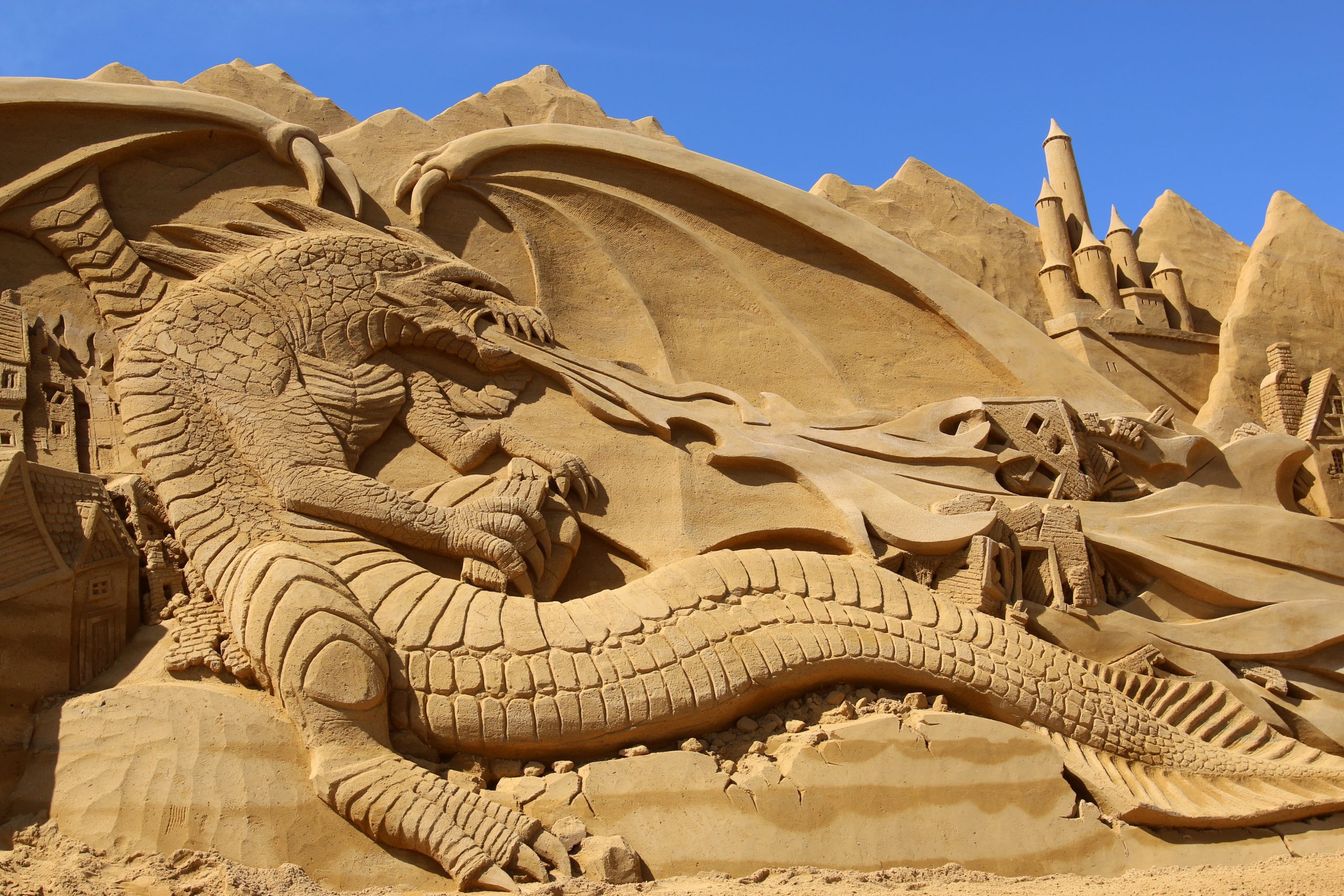 Sandskulptur af drage som spyr